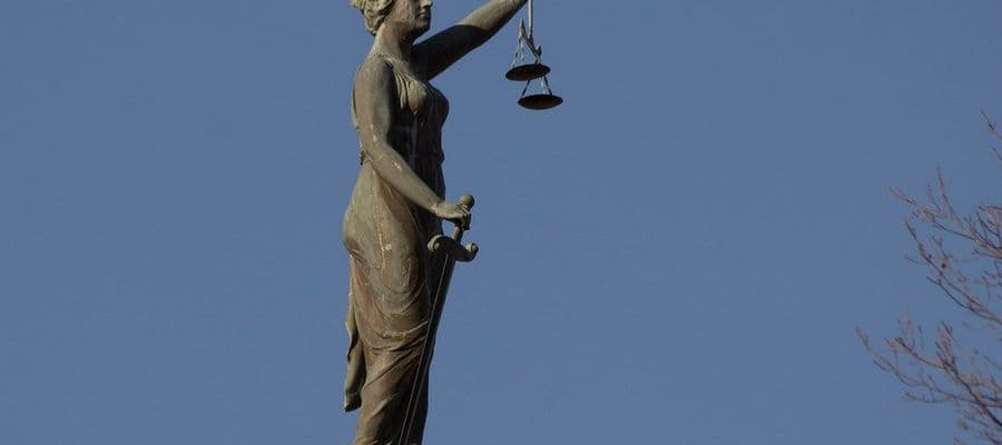 Statue de la Justice tenant une balance, au sommet d'un palais de justice
