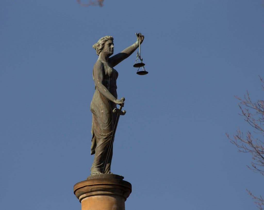 Statue de la Justice tenant une balance, au sommet d'un palais de justice
